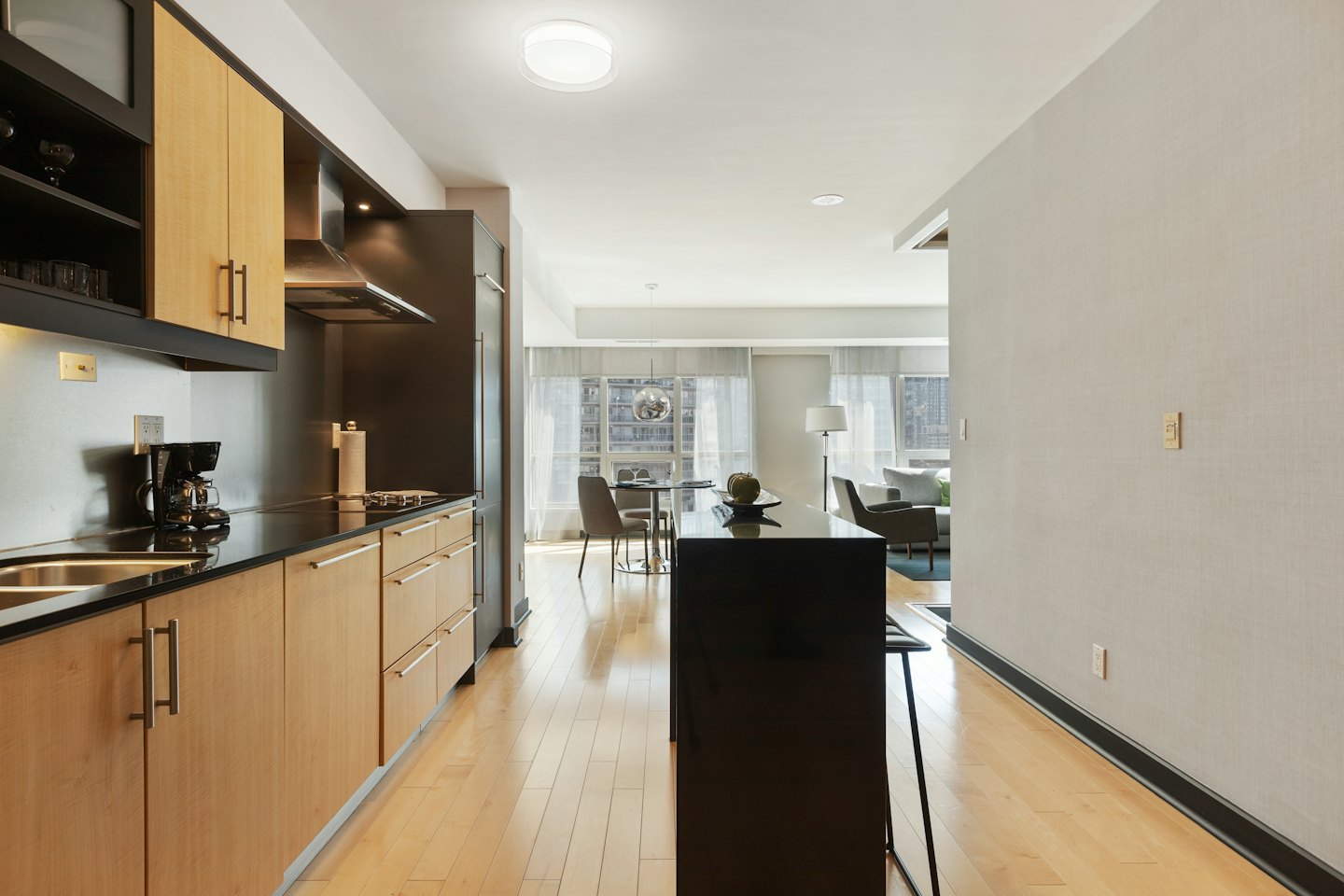 Modern open-concept kitchen and living space with city view.
